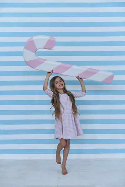 Little girl holding giant candy cane — Stock Photo, Image