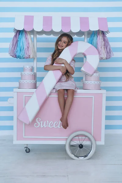 Menina sentada no carrinho de doces — Fotografia de Stock