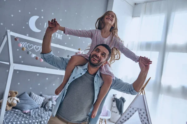 Vader boekwaarde dochter op schouders — Stockfoto