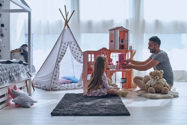 Vader en dochter spelen met poppenhuis — Stockfoto