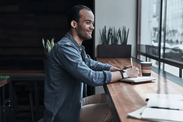 Beau étudiant écrivant dans un journal intime — Photo