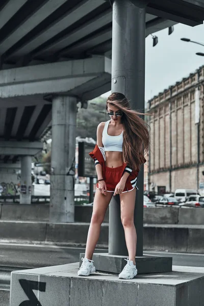 Kvinna i sport kläder poserar i street — Stockfoto