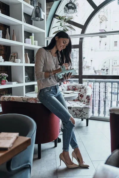 Mooie lachende vrouw schrijven notities — Stockfoto