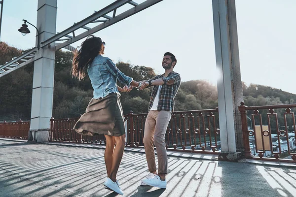 Стильная молодая пара танцует на мосту — стоковое фото