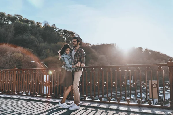 Романтическая пара, обнимающаяся на мосту — стоковое фото
