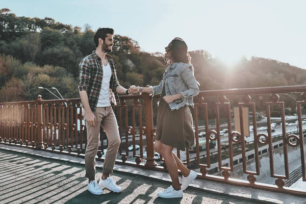 Paret höll händer och står på bron — Stockfoto