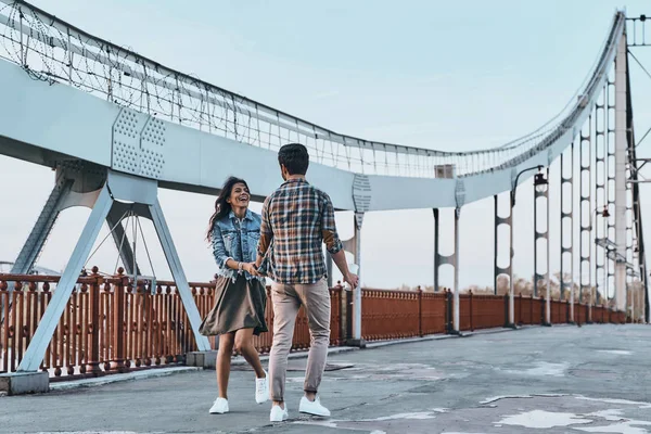 Coppia che si tiene per mano e cammina sul ponte — Foto Stock