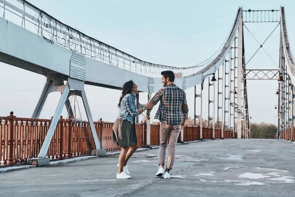 Пара держась за руки и идя по мосту — стоковое фото