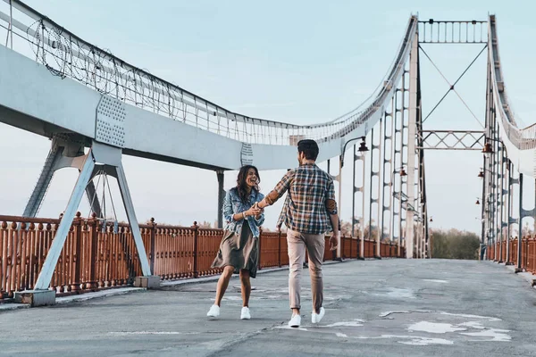 Coppia che si tiene per mano e cammina sul ponte — Foto Stock