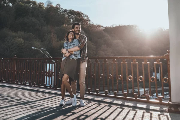 Hombre abrazando atractiva mujer en puente —  Fotos de Stock