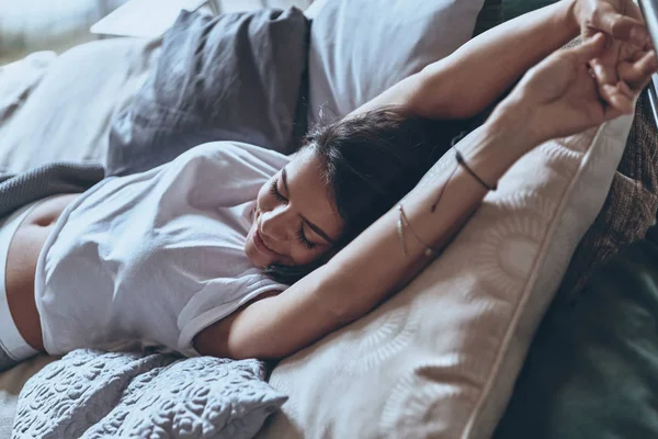 Kvinne som sover i senga – stockfoto