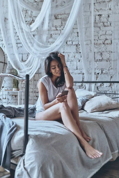 Brunette vrouw doorbladeren smartphone — Stockfoto