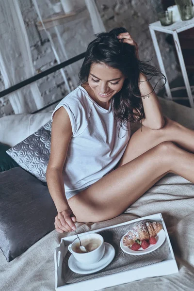 Mujer disfrutando del desayuno en la cama — Foto de Stock