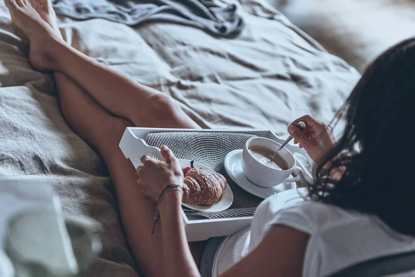 Mujer disfrutando del desayuno en la cama —  Fotos de Stock