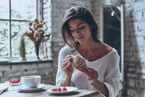 Mulher desfrutando de croissant fresco — Fotografia de Stock