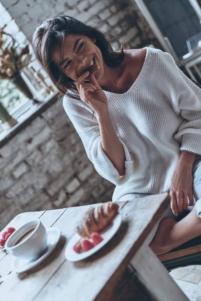 Bruneta žena jíst chutné croissant — Stock fotografie