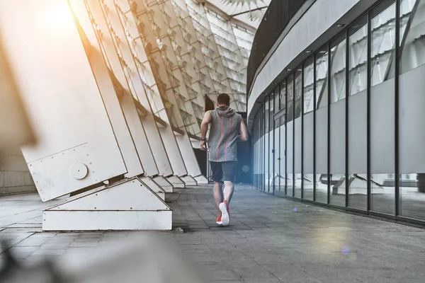 Man joggen rond stadion gebouw — Stockfoto
