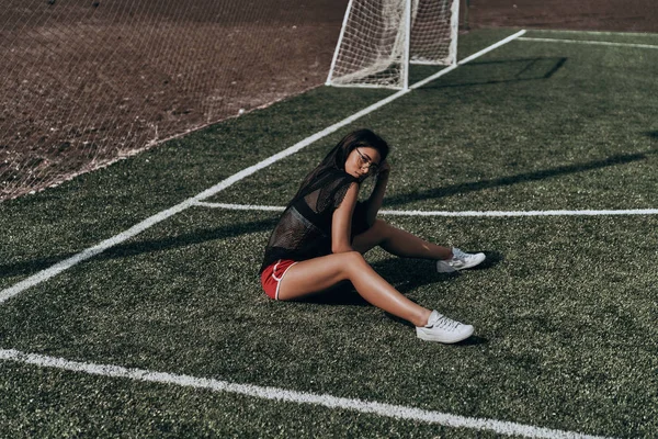 サッカーのフィールドで座っている女性 — ストック写真