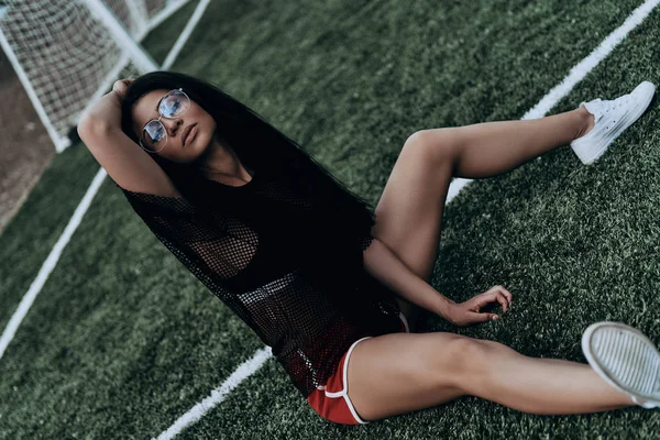 Frau sitzt auf Fußballplatz — Stockfoto