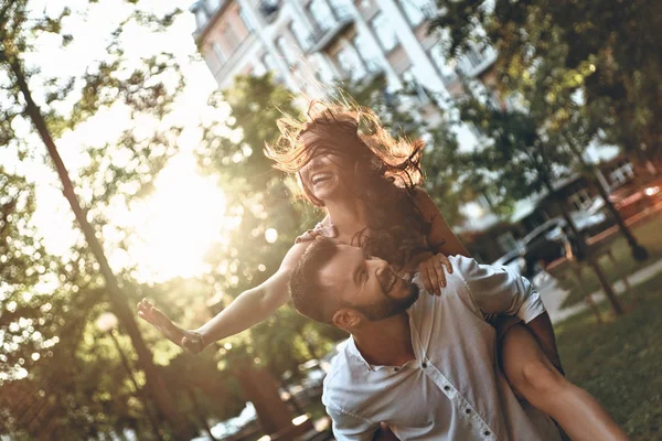 Uomo dando la sua ragazza a cavalluccio — Foto Stock