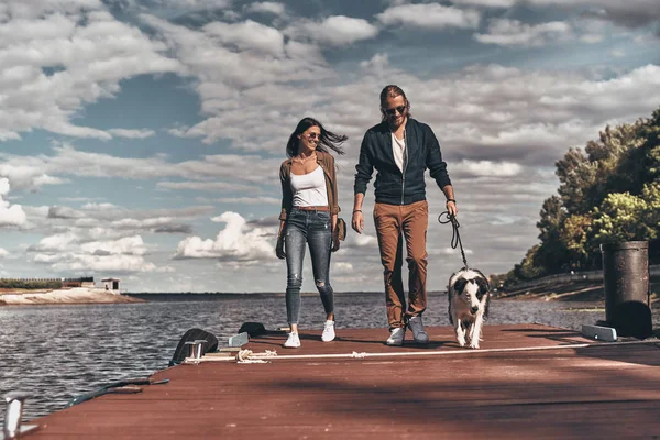 Beautiful couple walking with dog — Stock Photo, Image