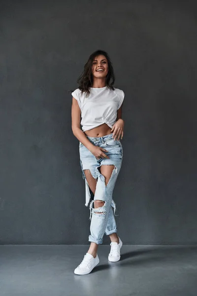 Brunett kvinna i rippade jeans — Stockfoto