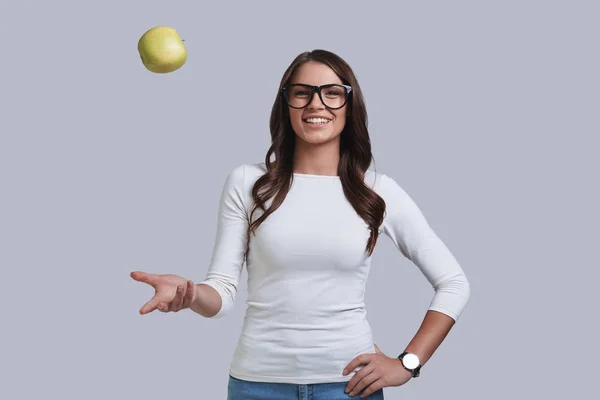 Piękna kobieta rzuca jabłko — Zdjęcie stockowe