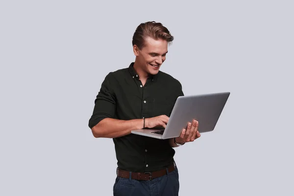 Όμορφος νεαρός άνδρας, χρησιμοποιώντας φορητό υπολογιστή — Φωτογραφία Αρχείου