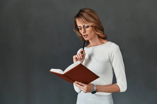 Vrouw denken en schrijven van notities in dagboek — Stockfoto