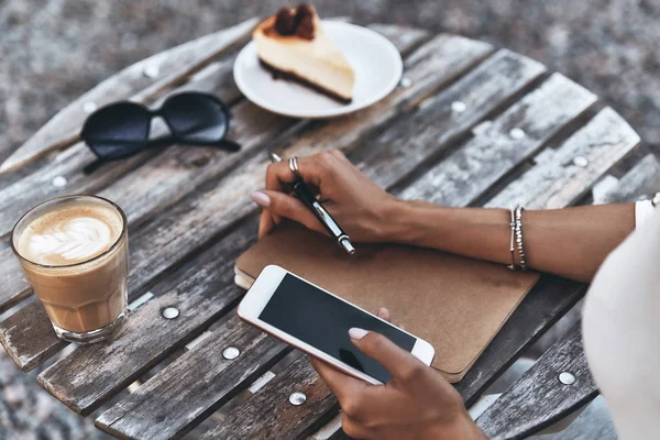 Mujer sentada en la cafetería en la mesa de madera — Foto de Stock