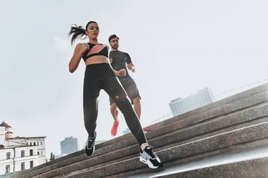 Sportif çift merdivenlerden aşağı çalışan