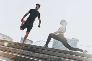 Sportif çift germe egzersizleri yapıyor