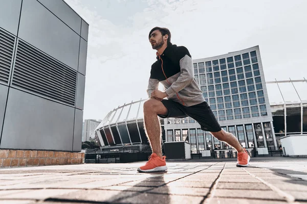 Homem esportivo fazendo exercícios de alongamento — Fotografia de Stock