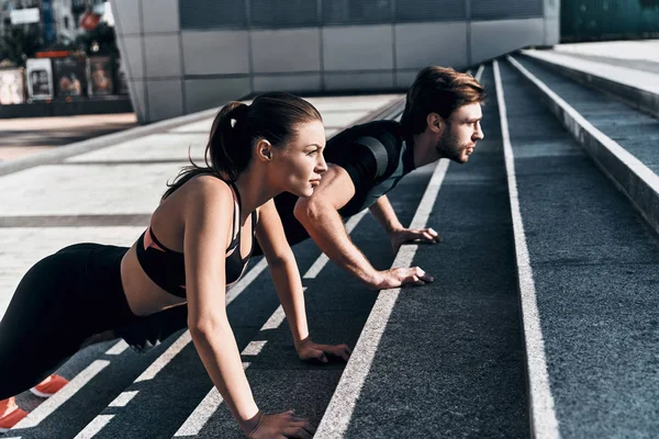 Paar doet push ups — Stockfoto