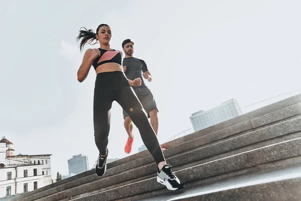 Pareja deportiva corriendo por las escaleras — Foto de Stock