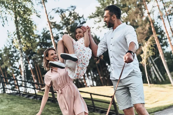 Mother and father swinging daughter — Stock Photo, Image