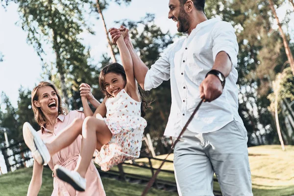 Mãe e pai balançando filha — Fotografia de Stock