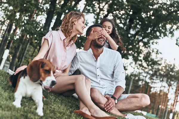 Flickan sitter i fältet med föräldrar — Stockfoto