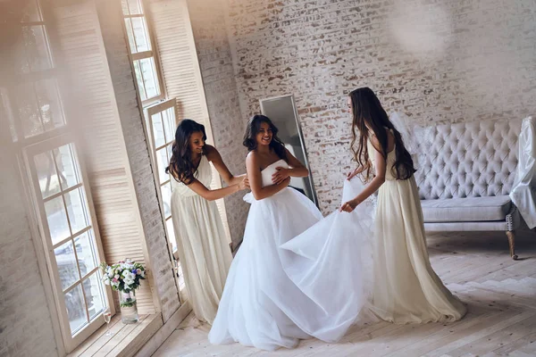 Demoiselles d'honneur aider la mariée à s'habiller — Photo