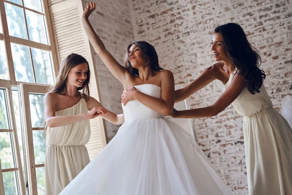 Demoiselles d'honneur aider la mariée à s'habiller — Photo