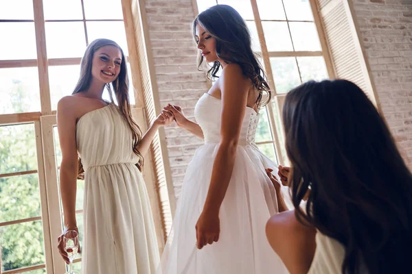 Demoiselles d'honneur aider la mariée à s'habiller — Photo