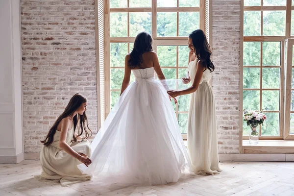 Demoiselles d'honneur aider la mariée à s'habiller — Photo