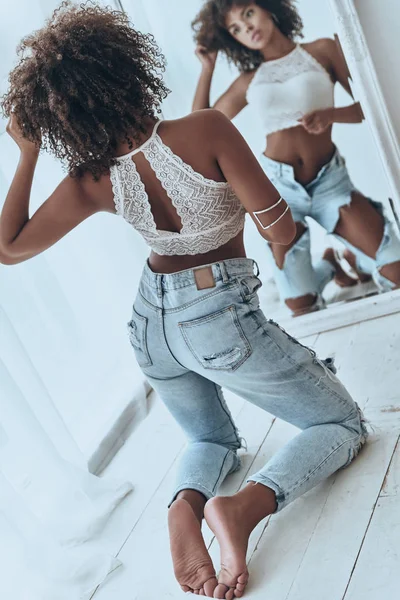 Женщина позирует и носит порванные джинсы — стоковое фото
