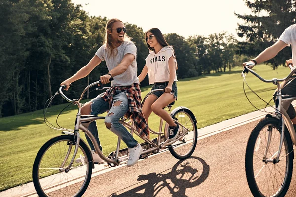 Amici godendo di andare in tandem biciclette — Foto Stock