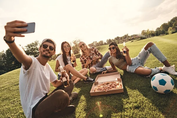 Amigos comendo pizza no piquenique — Fotografia de Stock