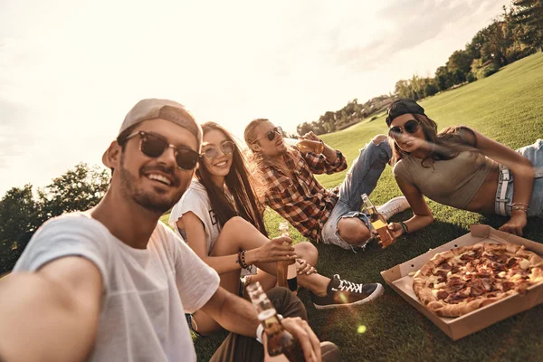 Amigos comiendo pizza en el picnic — Foto de Stock