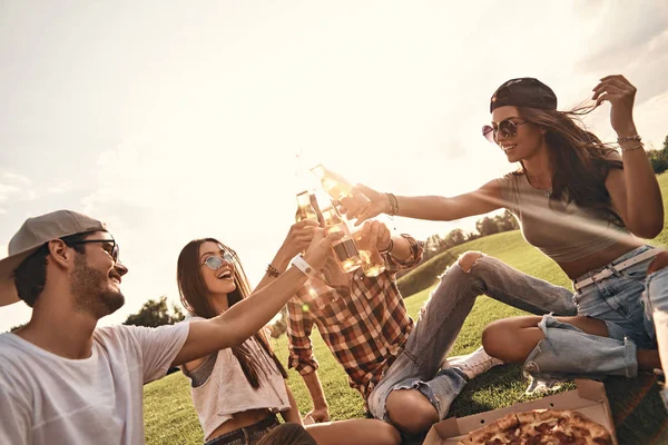 Vänner som äter pizza på picknick — Stockfoto
