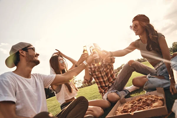 Друзья едят пиццу на пикнике — стоковое фото