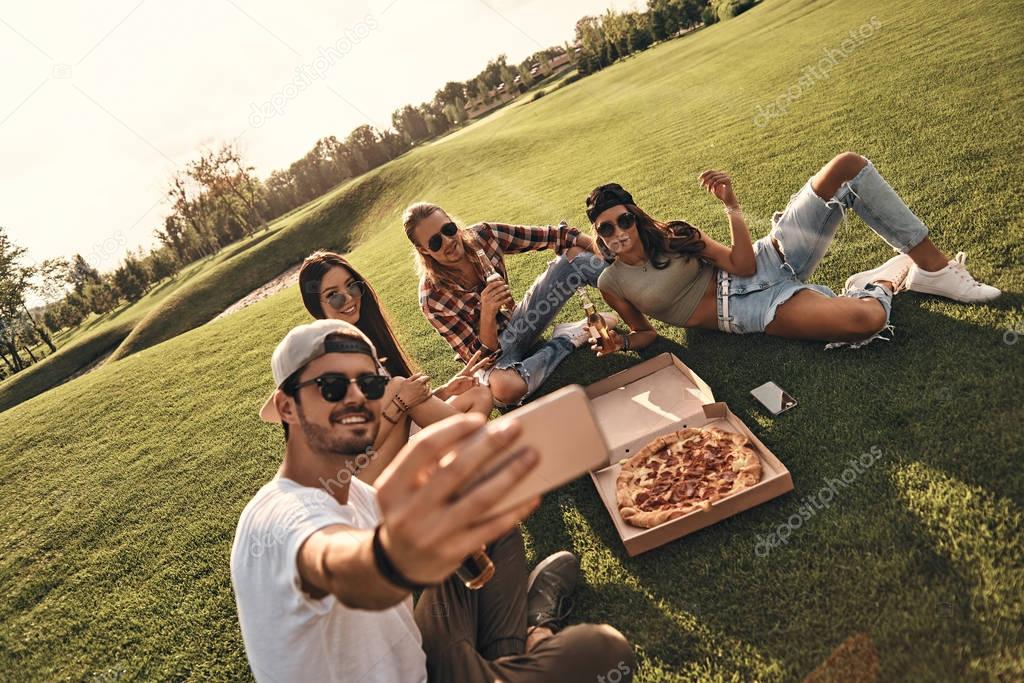 friends eating pizza on picnic