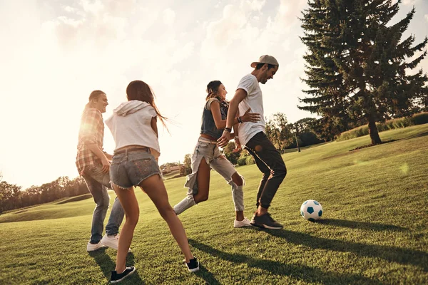 Quatro amigos jogando futebol — Fotografia de Stock